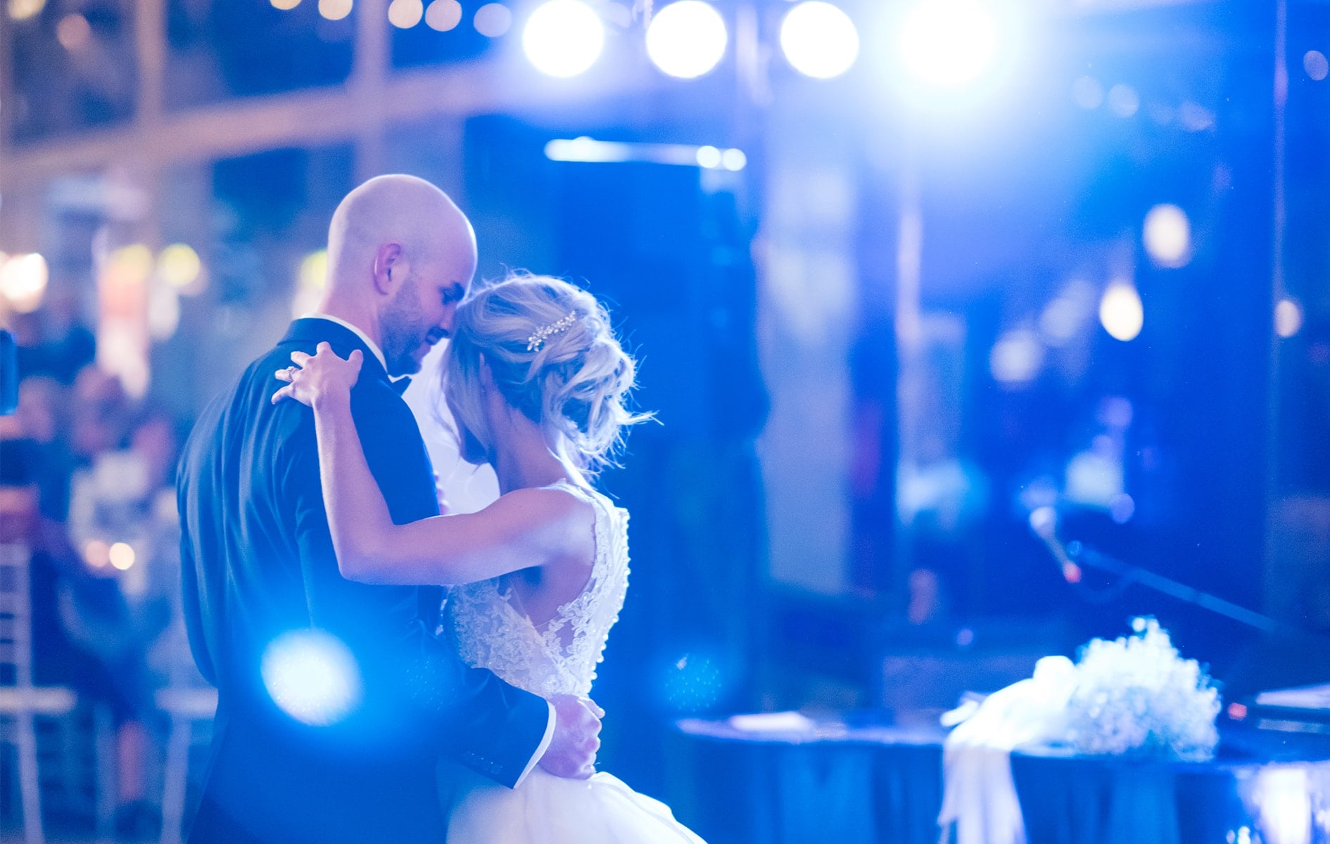 bride and groom dancing under lights at wedding